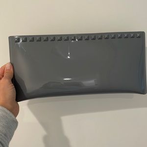 Carmen Sol Italian-made grey silicone clutch with grommets.